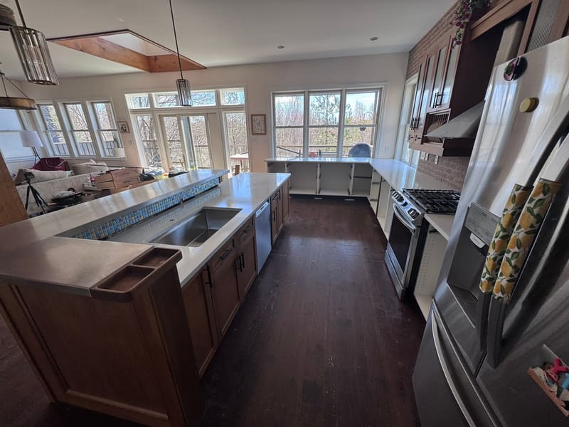Dark cabinetry with a pale stone island and perimeter counters