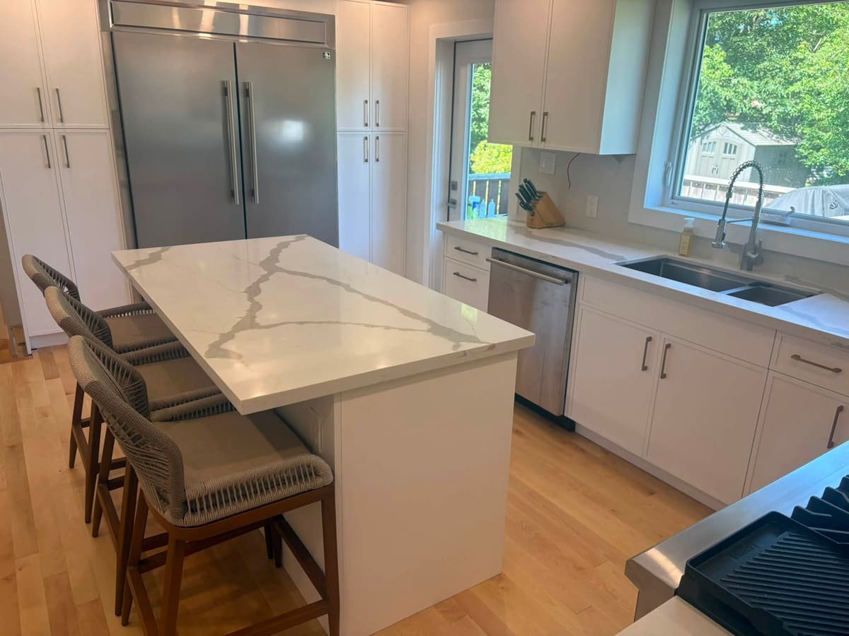 Quartz island and perimeter counters facing a garden window