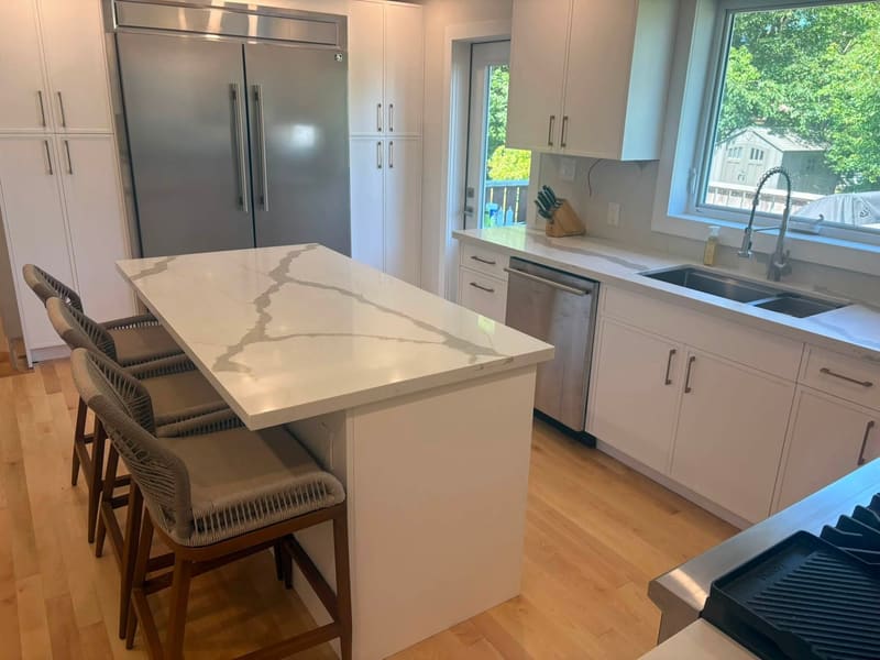 Quartz island and perimeter counters facing a garden window