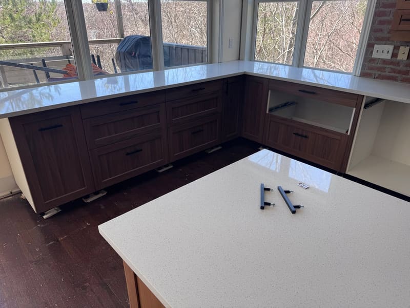 Quartz peninsula counter in front of windows looking onto the water