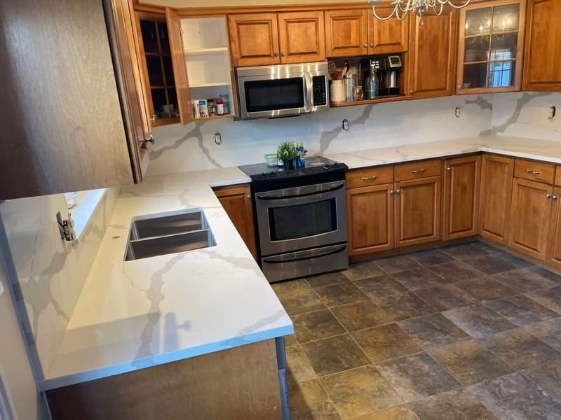 Veined quartz counters running up into a matching backsplash