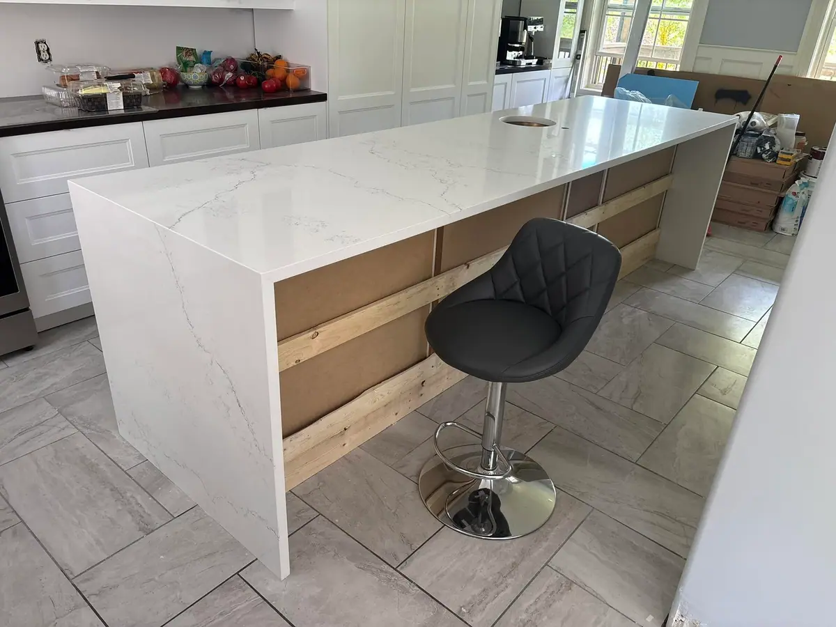 White quartz bar counter with a waterfall return and bar stool
