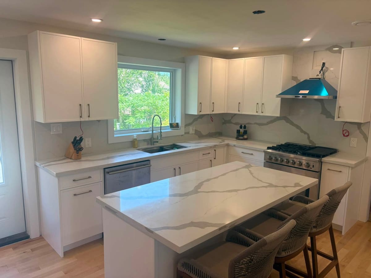 White shaker cabinetry topped with veined quartz counters
